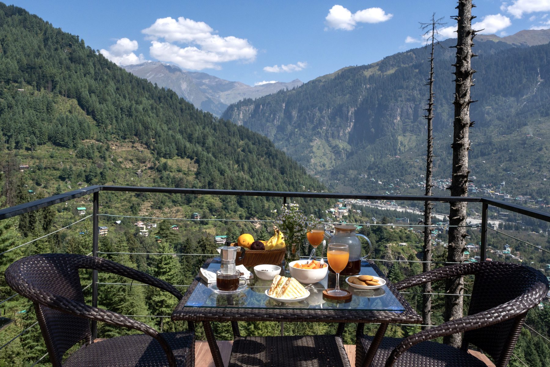A laid breakfast table with the valley and snow peaks beyond.