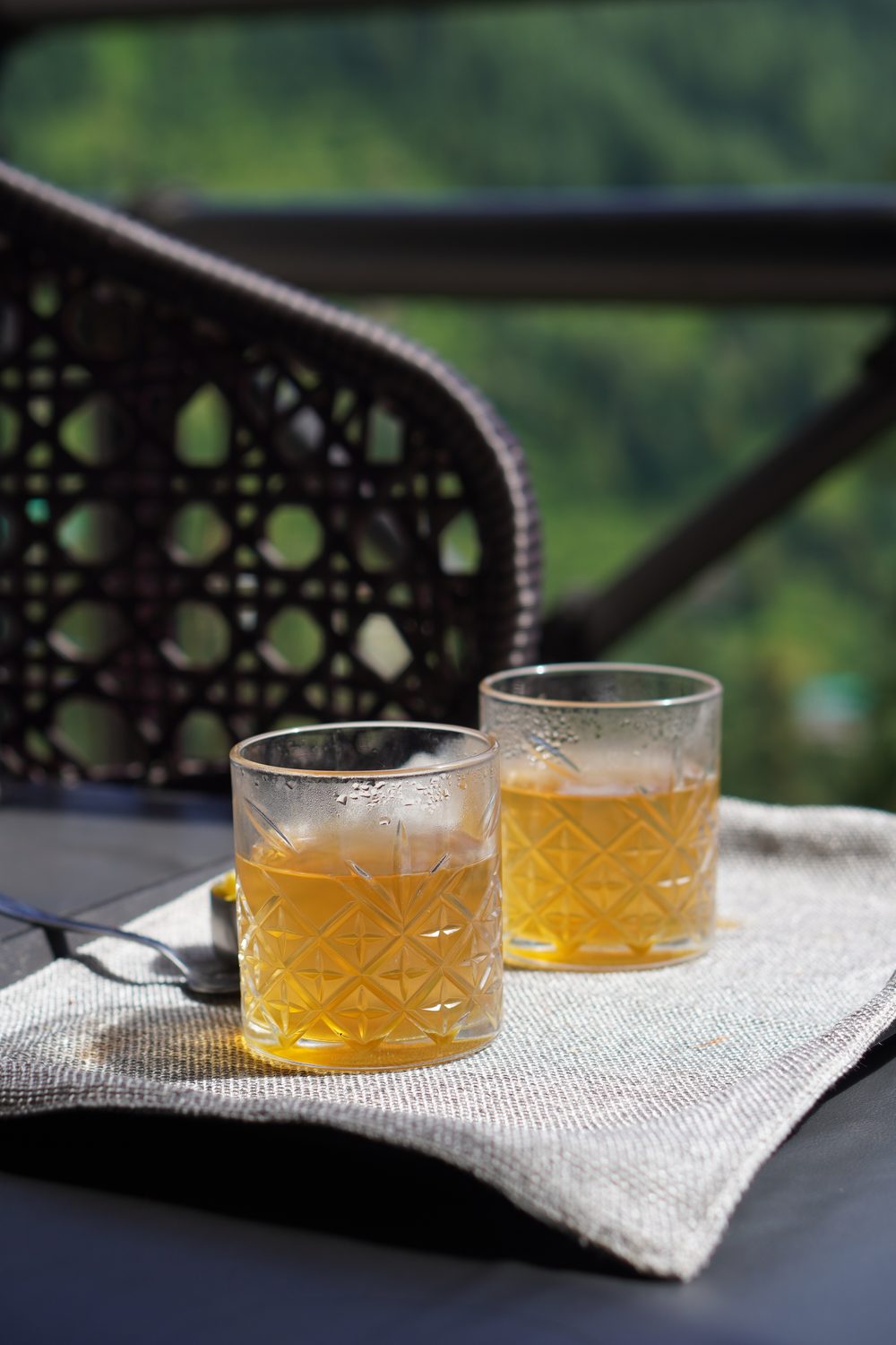 Two glasses of iced tea on a linen tray on the deck table.